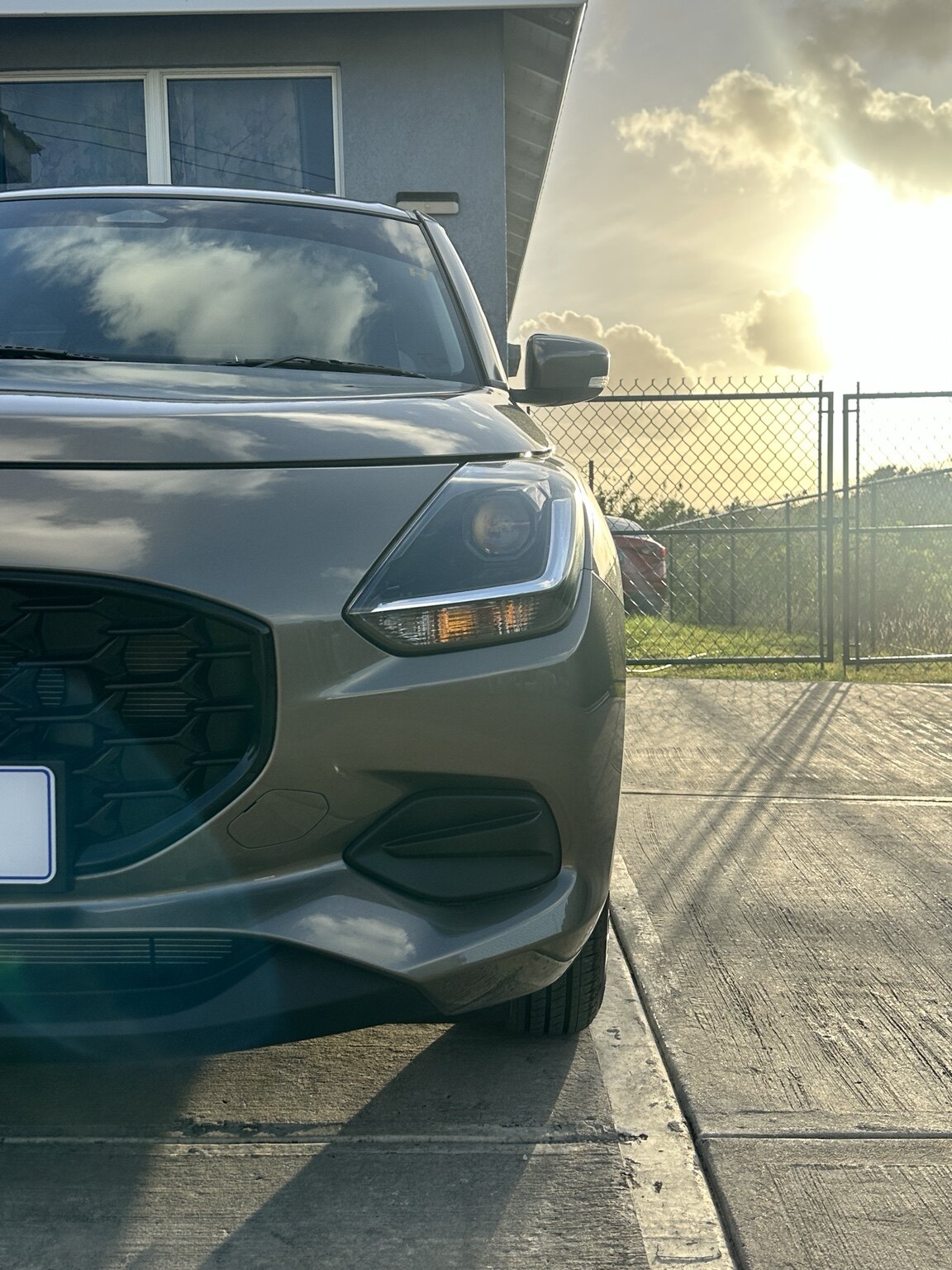 Front detail view of the grey Suzuki Swift at sunset